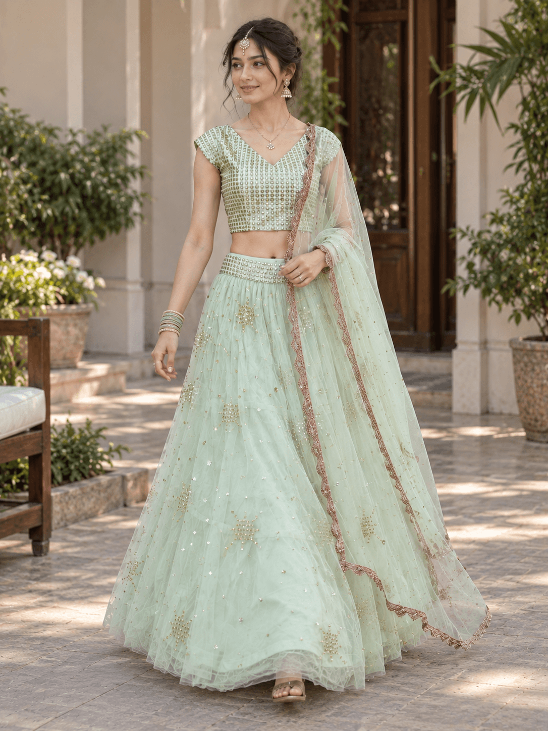 Front view of pastel green flared lehenga skirt featuring allover sequin floral motifs and embellished waistband
