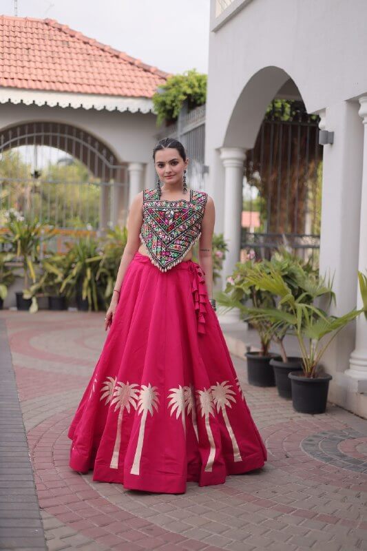 Full-length view of magenta pink flared lehenga choli with multicolor embroidered blouse and gold hem motifs