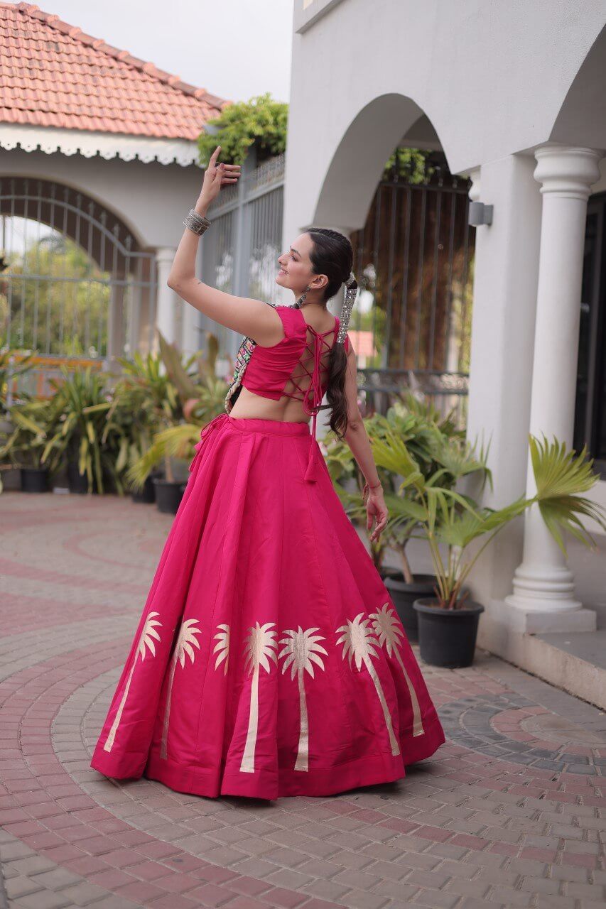 Back three-quarter view of magenta pink flared lehenga with gold Coconut Gota motifs along the hem