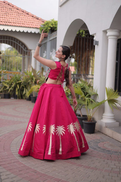 Back three-quarter view of magenta pink flared lehenga with gold Coconut Gota motifs along the hem