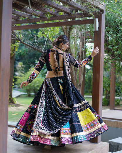 Back view of model wearing a black chaniya choli with tie-up backless blouse and draped dupatta across the flared skirt