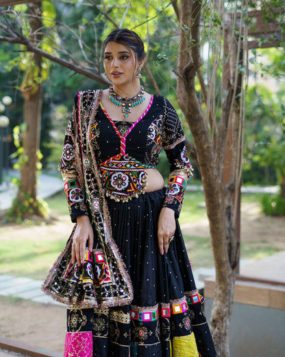 Three-quarter front view of black chaniya choli highlighting the multi-color embroidered patchwork hem and long sleeve blouse