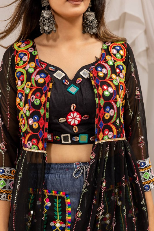 Close-up detail of black sweetheart neck crop top and shrug bodice adorned with cowrie shells and vibrant mirror embroidery