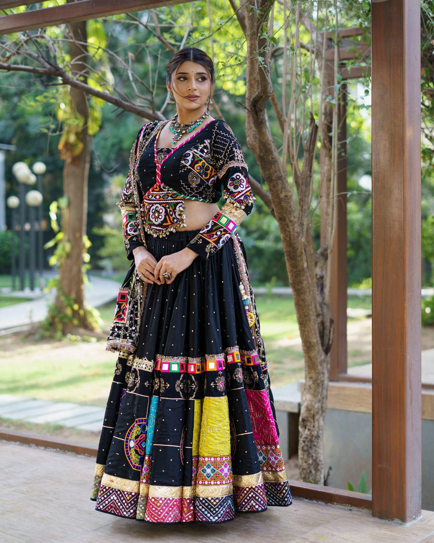 Full standing front shot of black chaniya choli ensemble featuring colorful embroidered border panels and matching dupatta