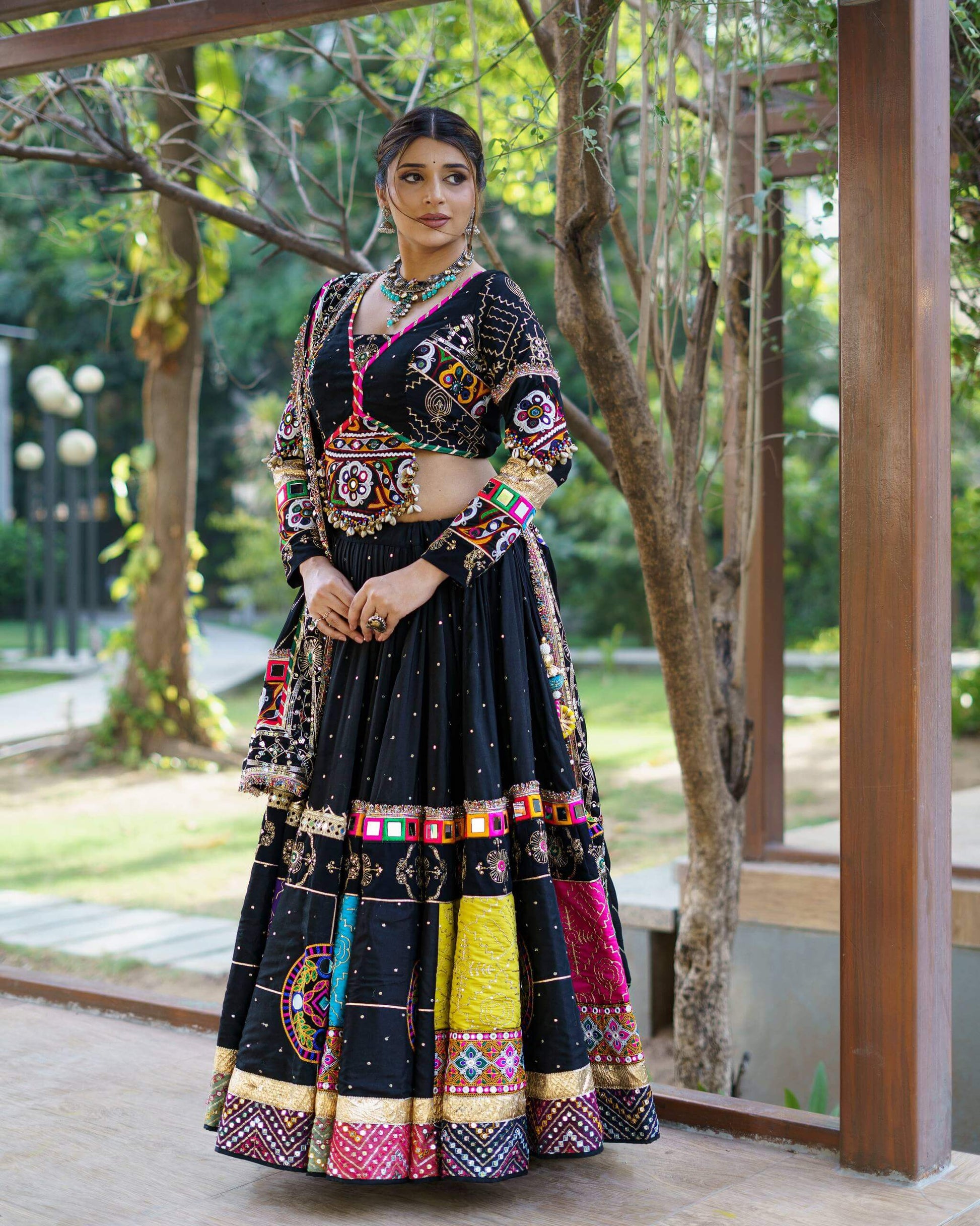 Full standing front shot of black chaniya choli ensemble featuring colorful embroidered border panels and matching dupatta