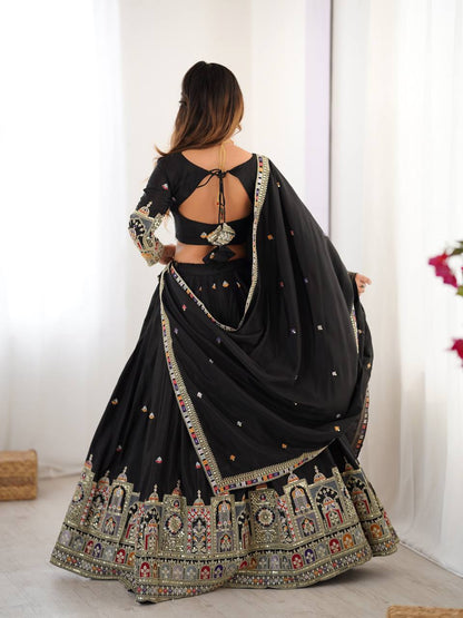 Back view of model wearing a black lehenga with tie-up back blouse and heavy embroidered hem border