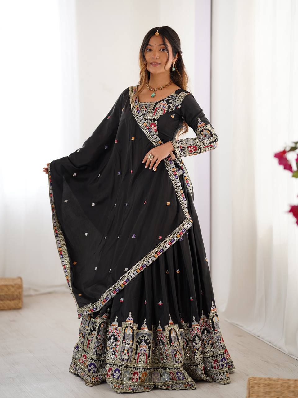 Model wearing a black flared lehenga choli with ornate jharokha motif border and matching dupatta