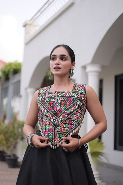Close-up of a multicolor patterned blouse with geometric and floral motifs, paired with a black lehenga
