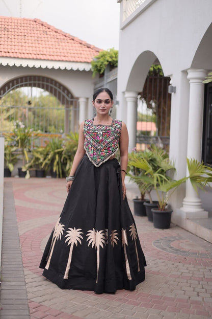Front view of a black lehenga choli with a multicolor patterned blouse and beige floral skirt motifs