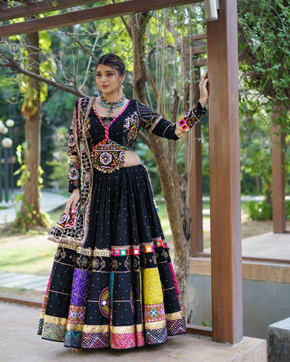 Full front view of model in a black Navratri chaniya choli featuring a central mirror-work blouse panel and colorful border patches