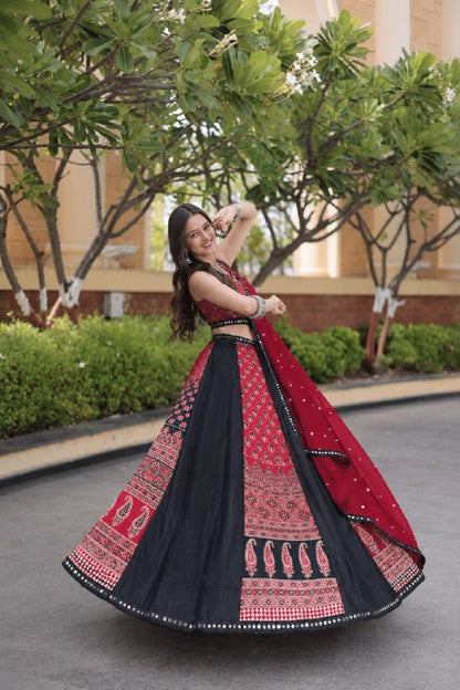 Outdoor twirl shot capturing the wide circular flare and ethnic paisley border panels of a black and red traditional printed lehenga.