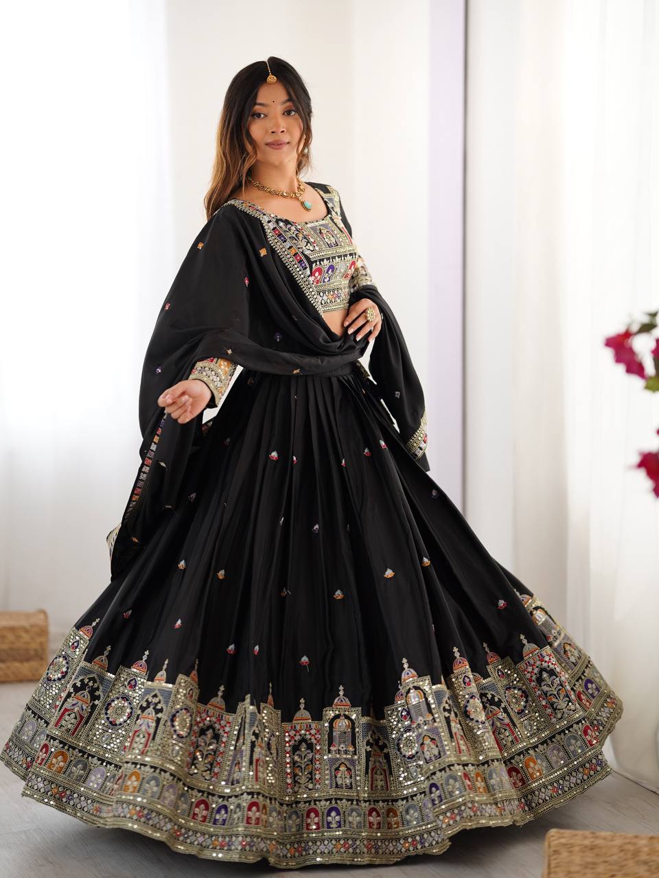 Full-length front shot of model in black pleated flared lehenga set with embroidered blouse and dupatta
