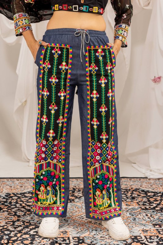 Front close-up view of straight-fit blue denim pants featuring colorful vertical mirror-work panels and embroidered figures