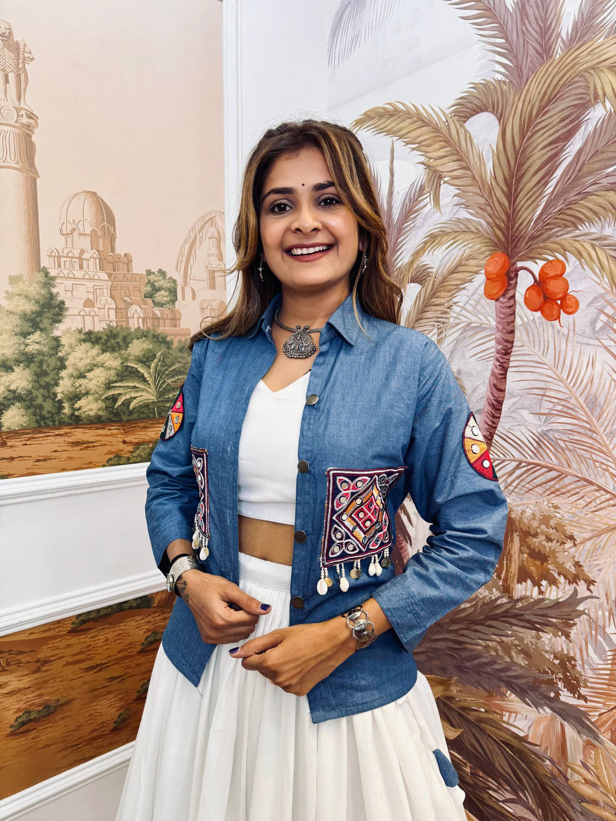 Mid-shot view highlighting the blue shirt-style jacket with colorful pocket embroidery and shell-coin latkan drops