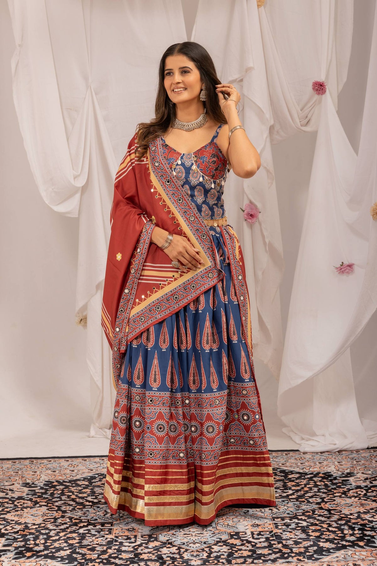 Full-length front view of model wearing blue printed lehenga choli set with draped maroon dupatta