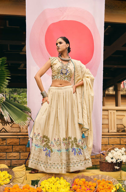 Full-length front view of a model in a cream flared lehenga choli with blue elephant motifs along the hemline