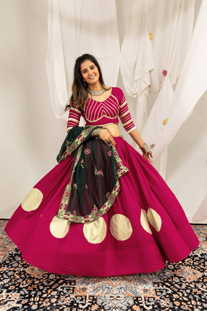 Wide flare display of a magenta lehenga skirt featuring large gold circular prints and a matching elbow-sleeve choli.