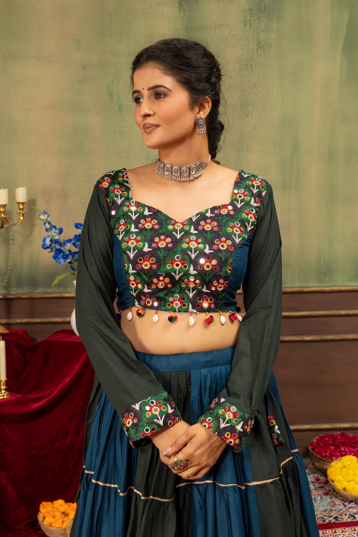 Mid-shot view of model wearing long-sleeve crop blouse with embroidered cuffs and tiered panelled skirt