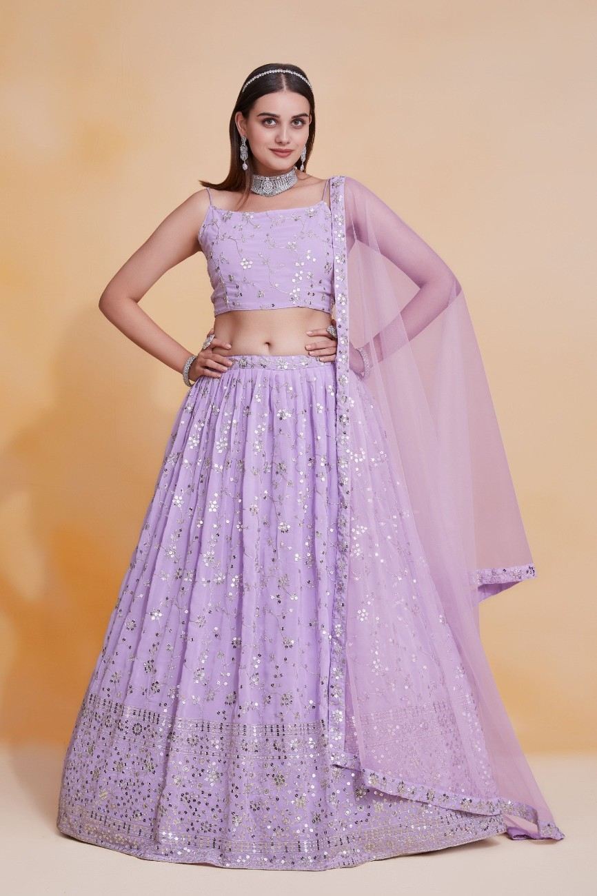 Model posing in a full-length lavender lehenga choli with sequin floral embroidery and matching sheer dupatta.