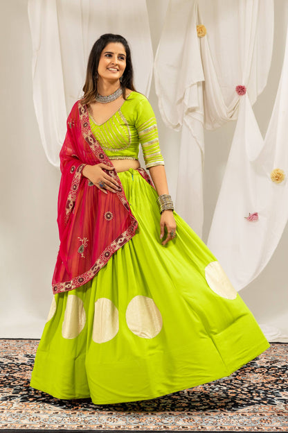 Three-quarter standing pose of a model dressed in a flared lime green lehenga skirt and elbow-sleeve striped choli.