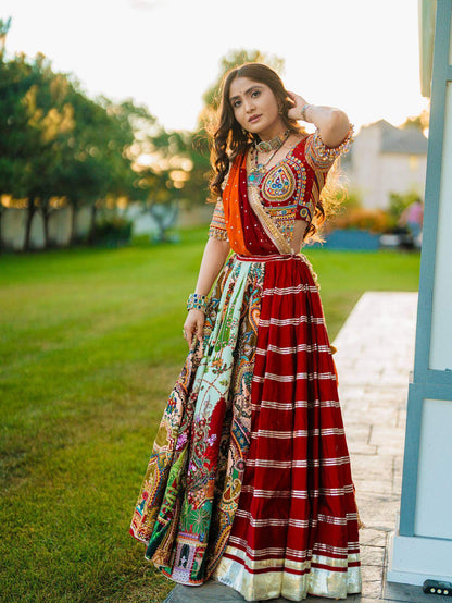 Front-angle full view of model in a red panelled lehenga with metallic hem border, multicolor print panels, and mirror choli