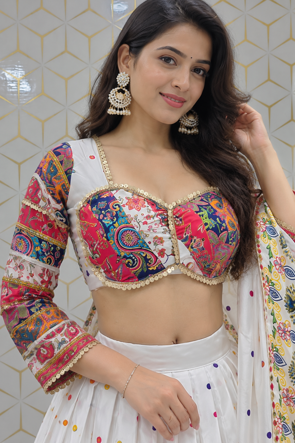 Close-up portrait highlighting the multicolor printed bustier blouse with gold sequin lace trims, sweetheart neckline, and statement pearl jhumkas.