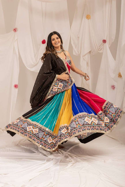 Model twirling in a multicolor pleated lehenga skirt displaying a wide flare and ornate geometric border.