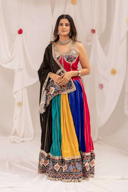 Model wearing a full-length multicolor panel lehenga with a pink choli and geometric printed border.