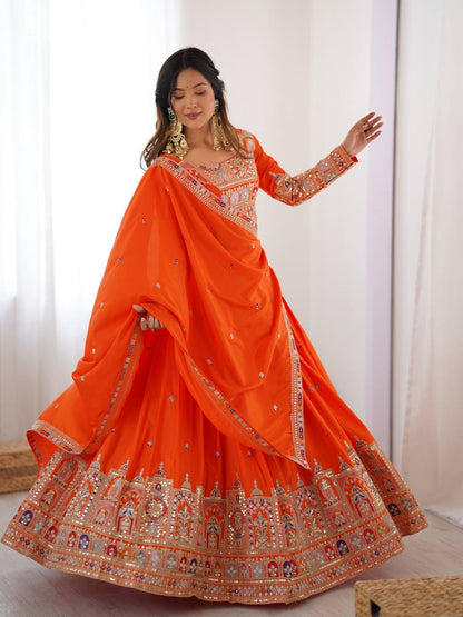 Front angle of model displaying the wide flare and embellished hemline of an orange traditional lehenga