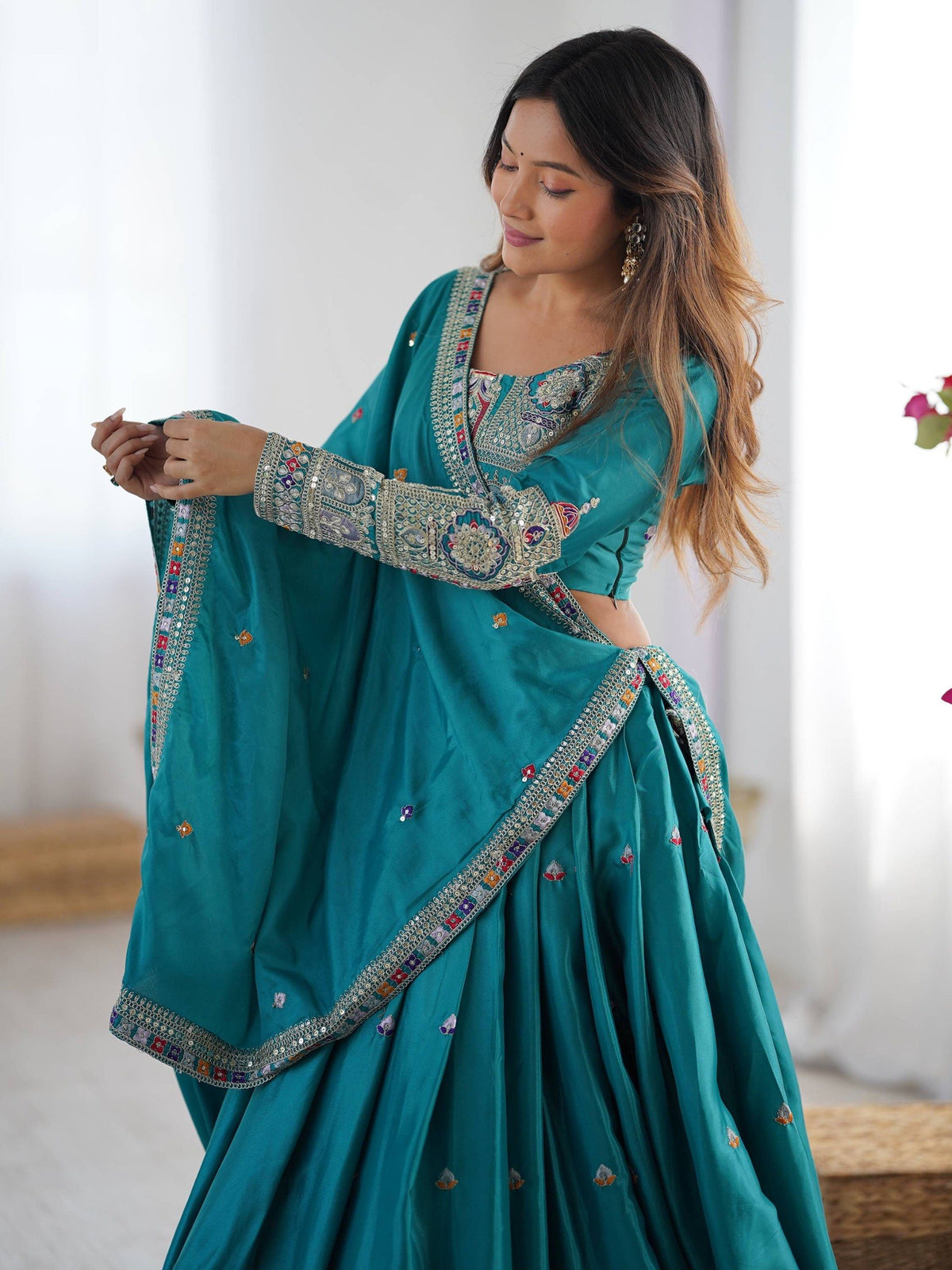Side view of peacock blue full-sleeve embroidered blouse with matching dupatta draped over the shoulder