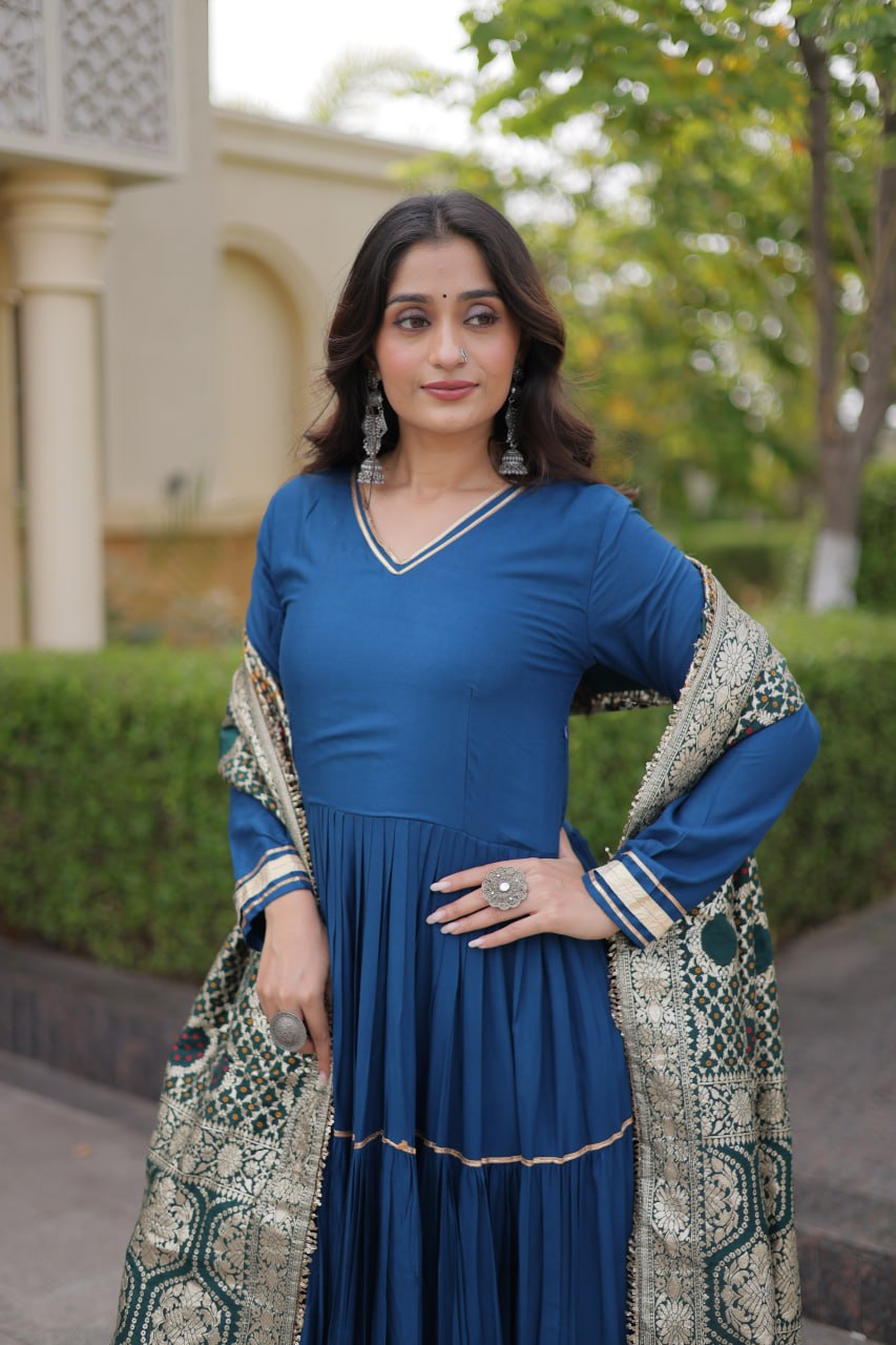 Mid-shot view highlighting the gold double-piping V-neckline, cuff borders, and woven dupatta pattern on a peacock blue gown.