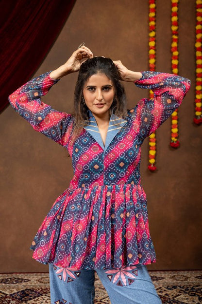 Front portrait pose of model with hands on hair wearing pink and navy bandhani printed flared tunic with denim collar