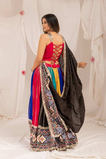 Rear angle view showing the criss-cross lace-up back design of the pink choli and pleated lehenga skirt.