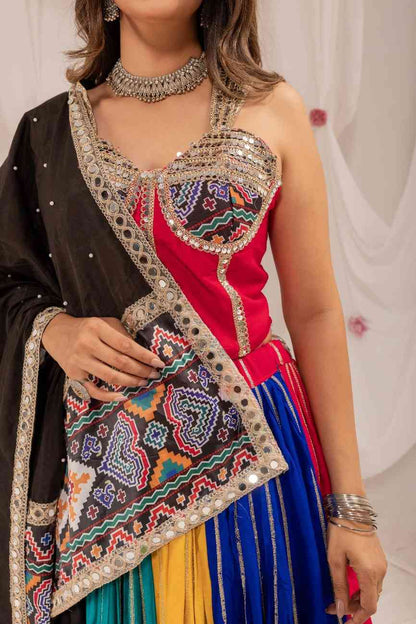 Close-up view of a pink corset-style choli featuring mirror work straps and geometric print panel detailing.
