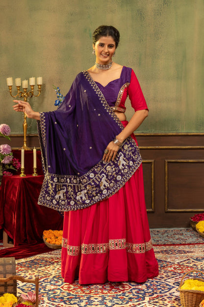 Full-length front view of model in pink lehenga skirt paired with purple dupatta featuring embroidered elephant borders