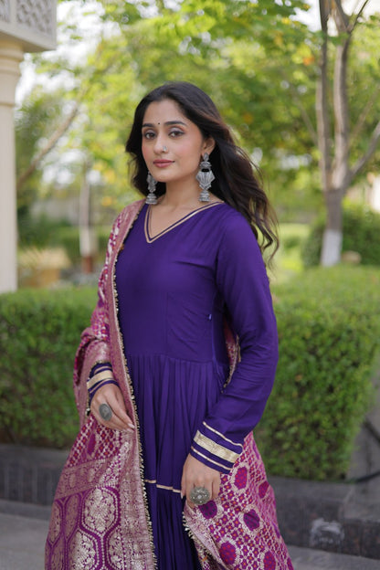 Three-quarter portrait of a model wearing a full-sleeve purple anarkali gown styled with a magenta woven jacquard dupatta and silver earrings.