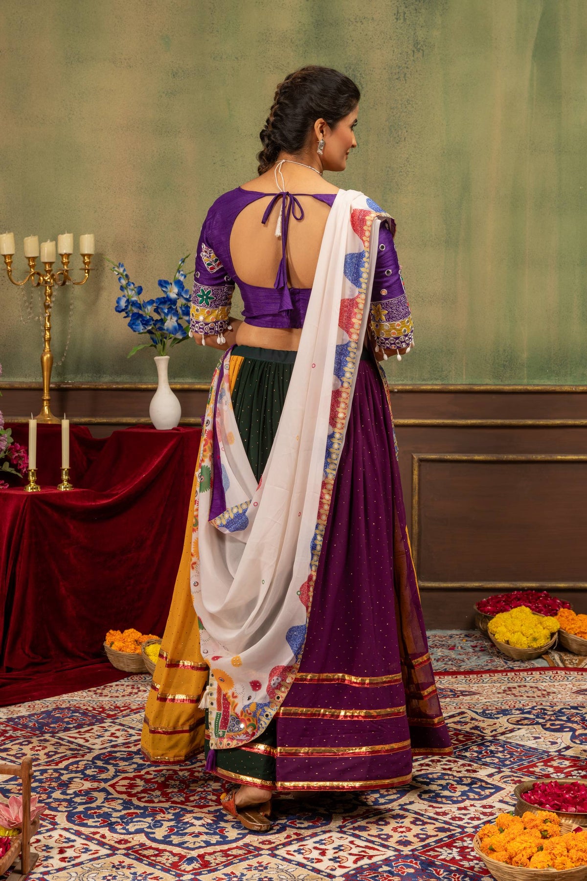 Back view of model wearing purple round cut-out back blouse with tie-up tassel dori and panelled flared skirt