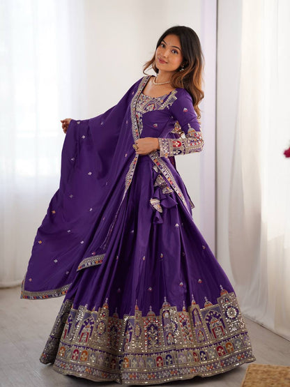 Side view of model posing in purple flared pleated lehenga choli with ornate border embroidery