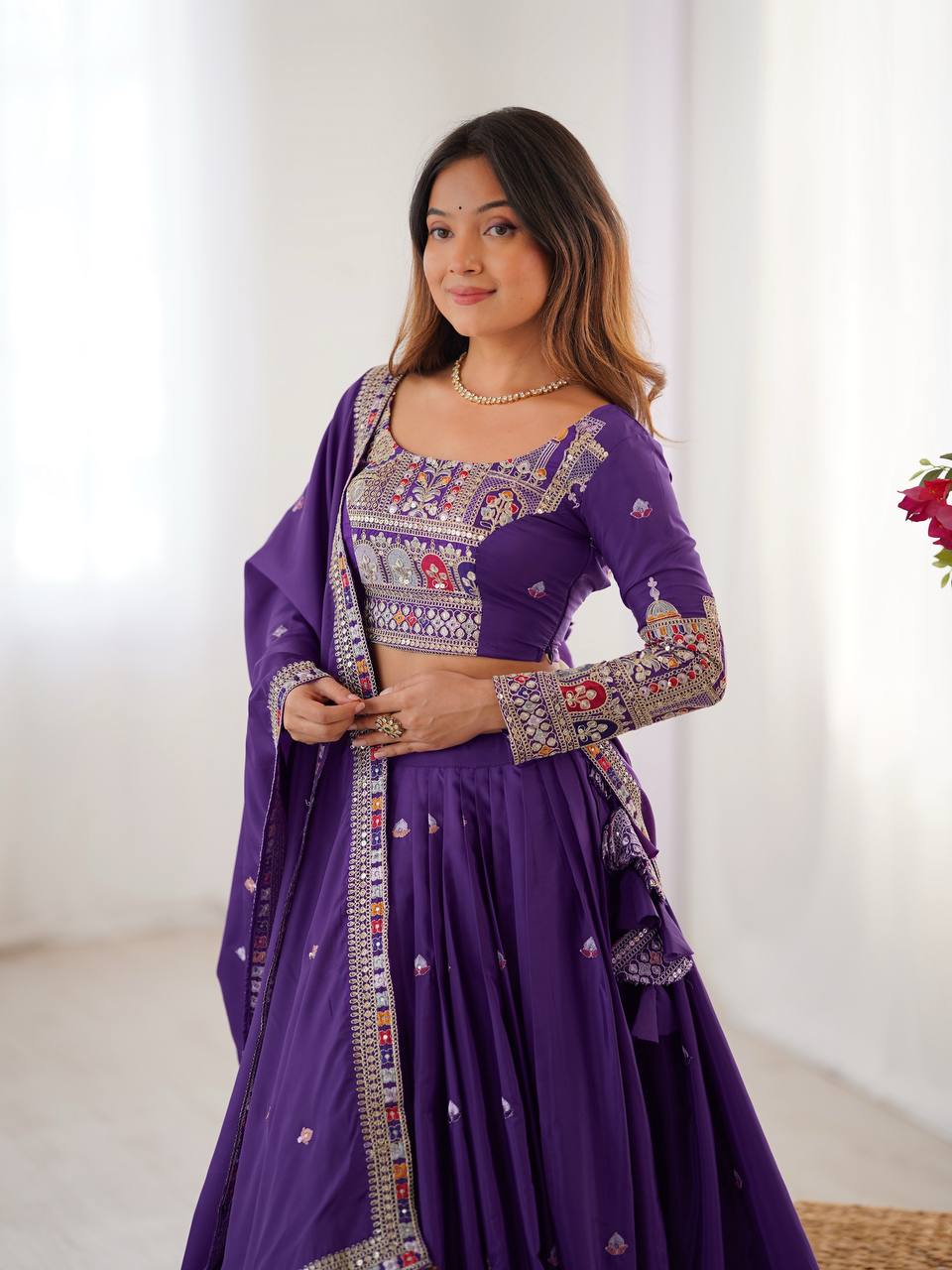 Medium shot of model showcasing purple full-sleeve blouse with embroidered cuffs and neckline details