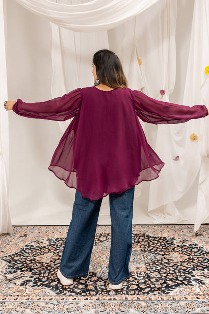 Back view of purple flared long-sleeve tunic top and wide-leg denim jeans