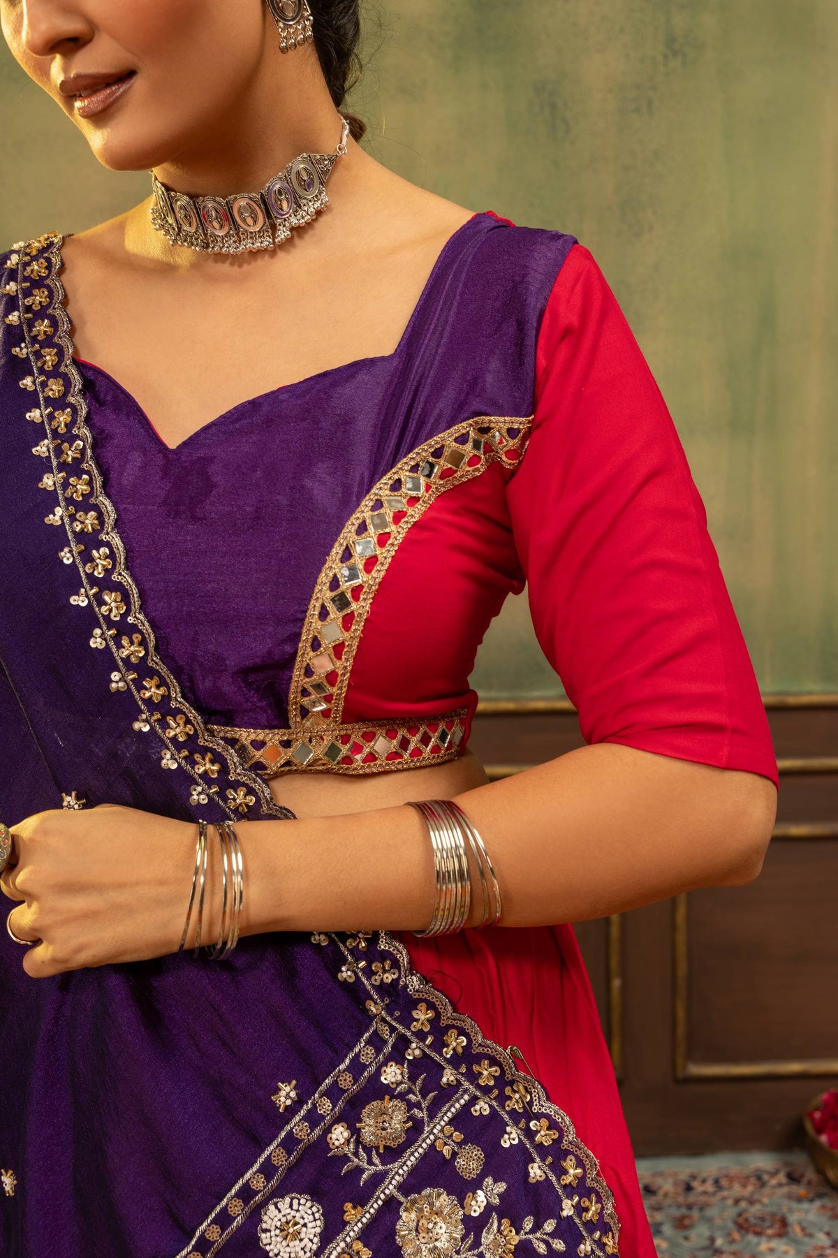 Close-up view of sweetheart neckline purple and pink blouse accented with geometric gold mirror lace