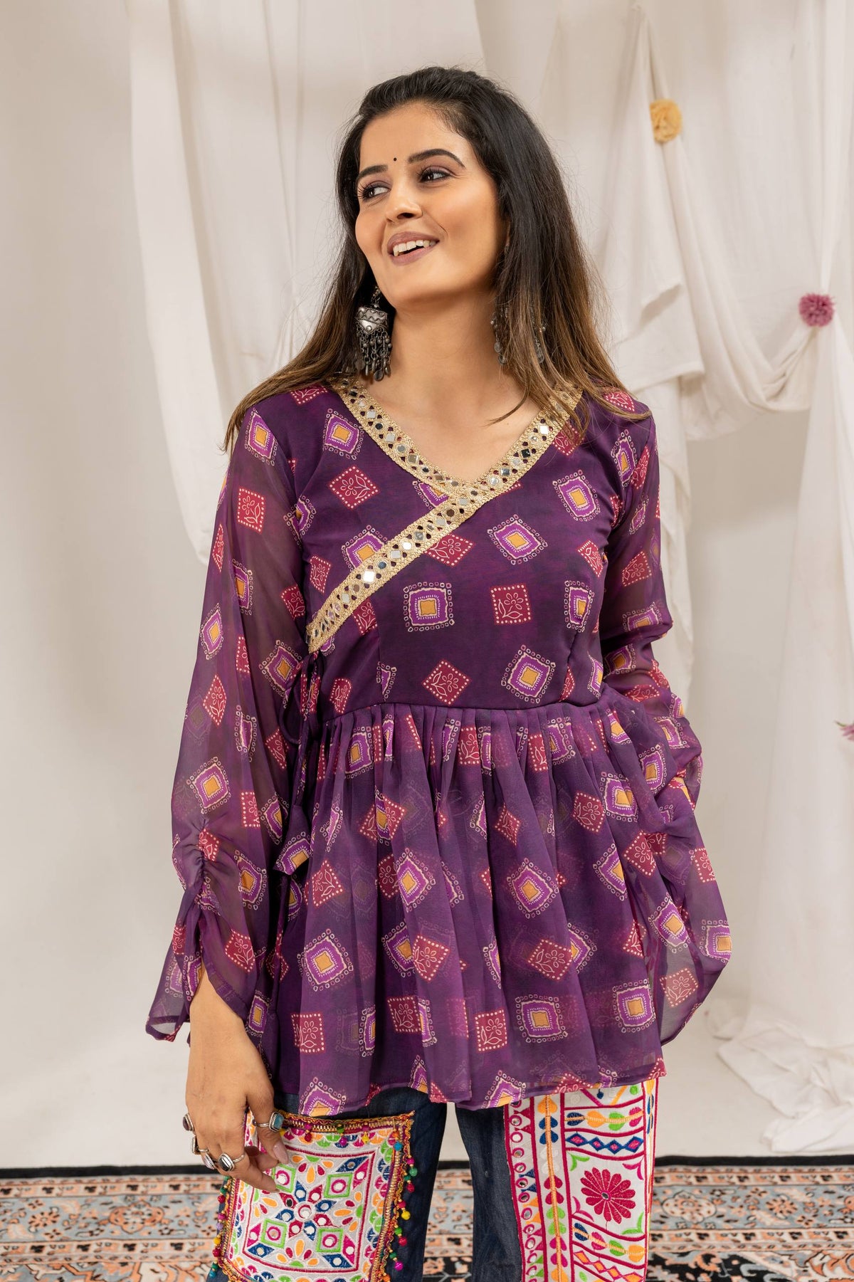 Close-up front view of purple printed angrakha peplum top with mirror work border along the neckline
