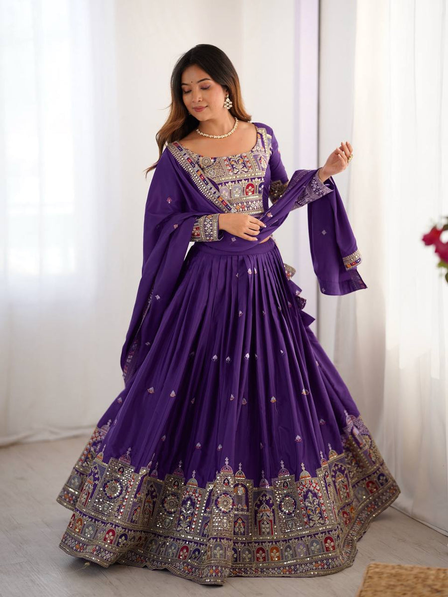 Front view of model in purple pleated lehenga choli featuring multicolor architectural motif border and full sleeves