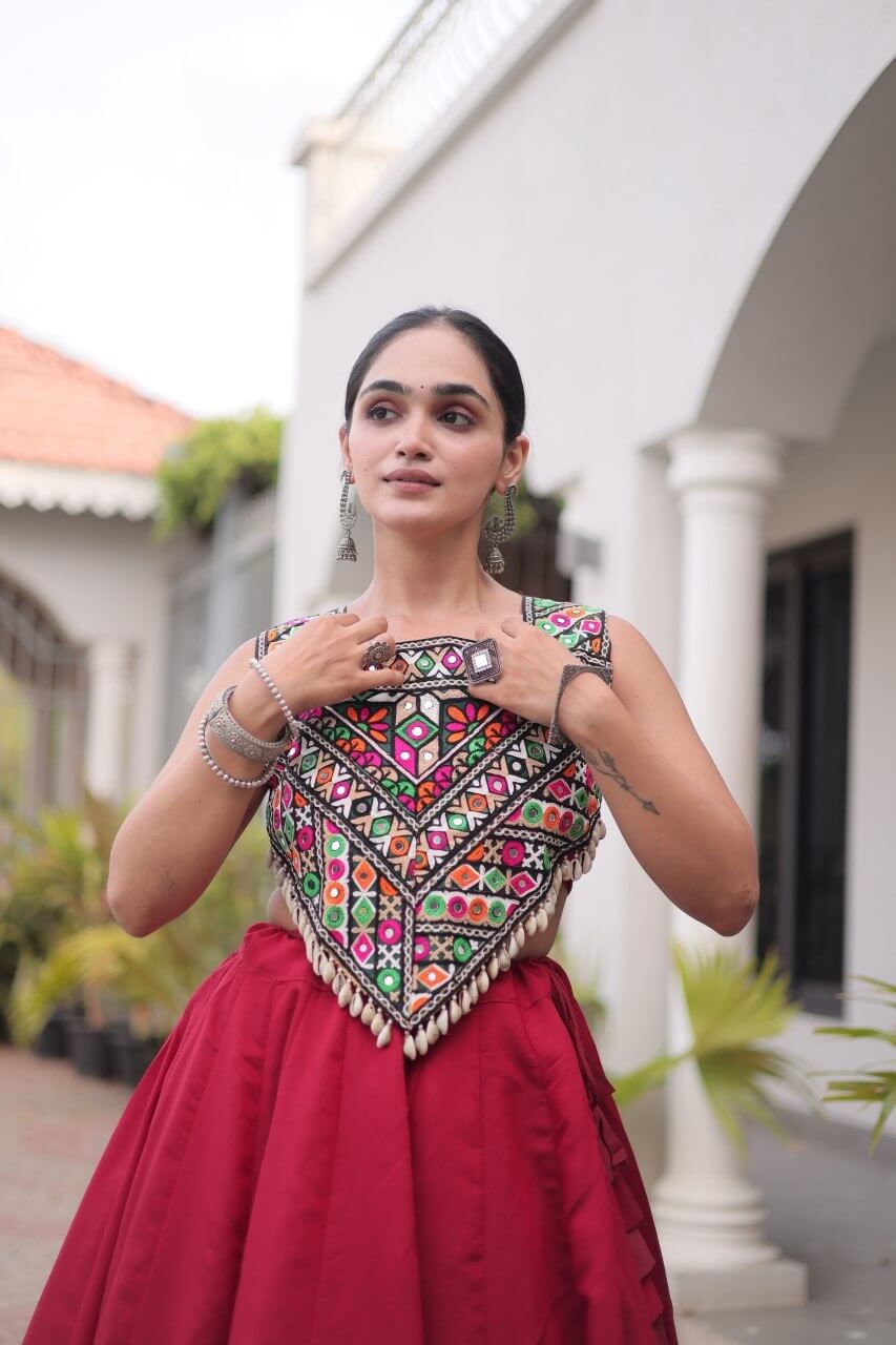 Close-up of the multicolored patterned blouse with cream trim and red lehenga