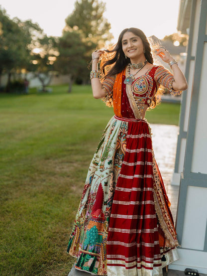 Full-length front shot of model wearing a red and multicolor printed panelled lehenga with mirror work blouse