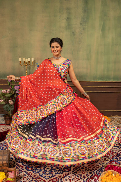 Full flared skirt view of model presenting red and multicolor kalidar bandhani lehenga with embroidered border