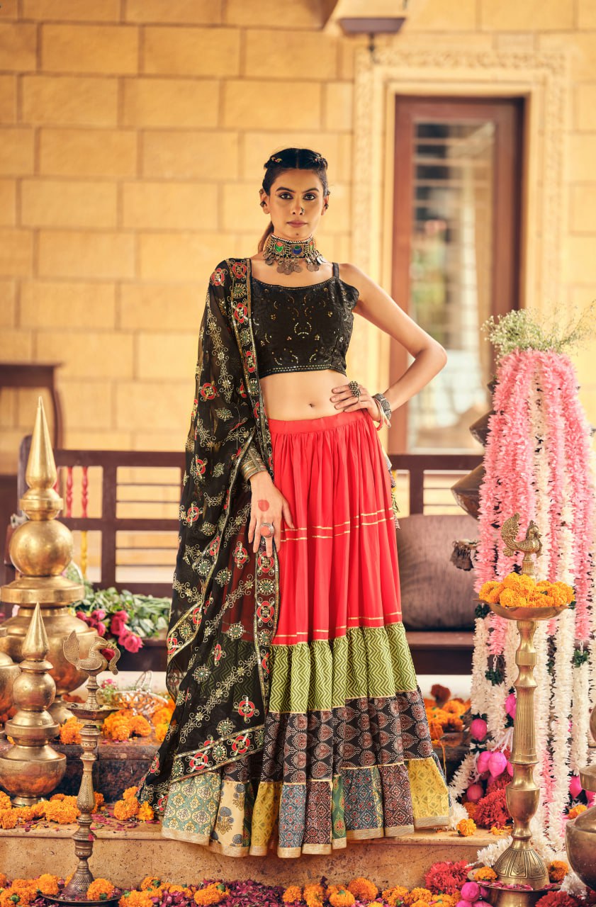 Full-length front view of a model showcasing the multi-printed bottom border tiers of a red flared lehenga with black dupatta
