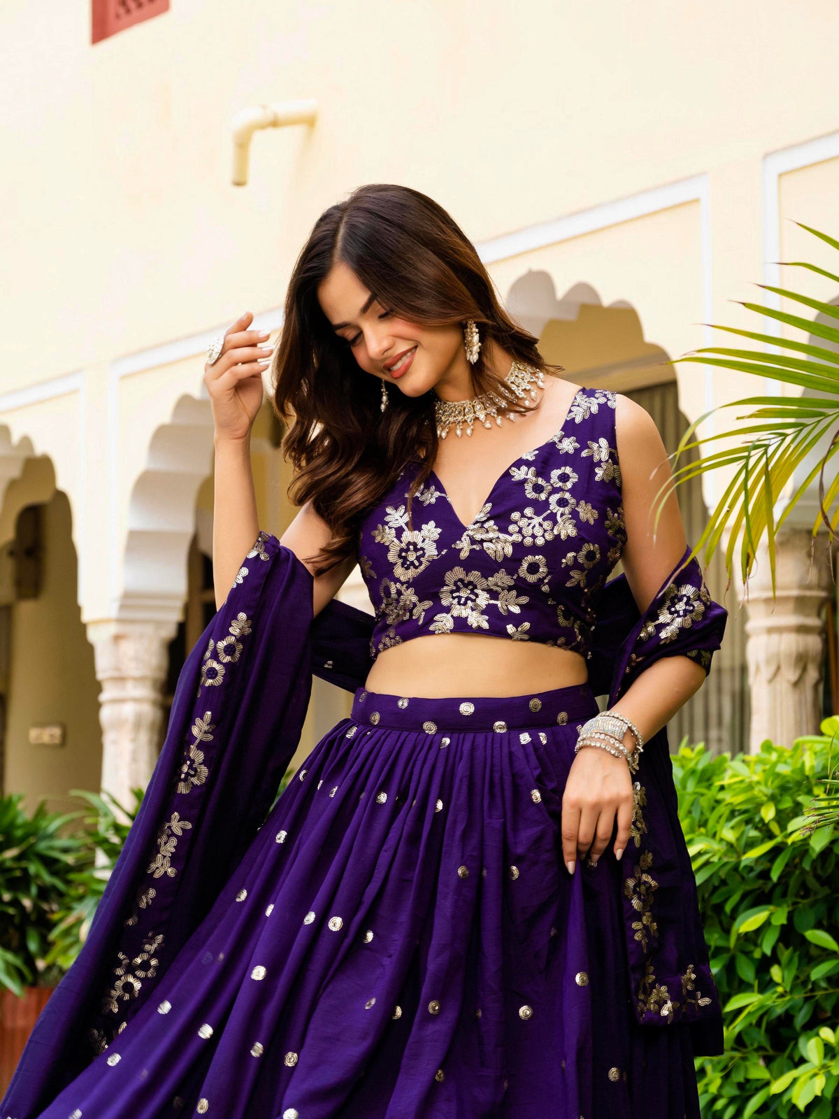 Three-quarter medium shot of royal purple sleeveless blouse and dupatta with gold floral thread embroidery