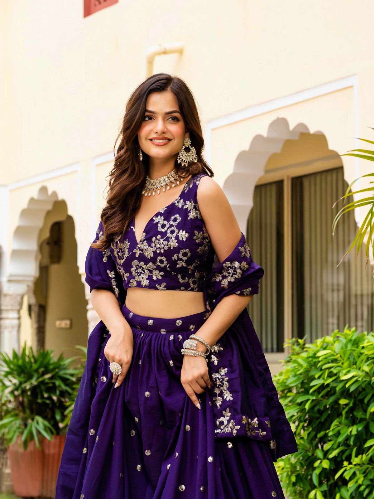 Medium portrait shot showing V-neck design and all-over gold floral motifs on royal purple choli blouse