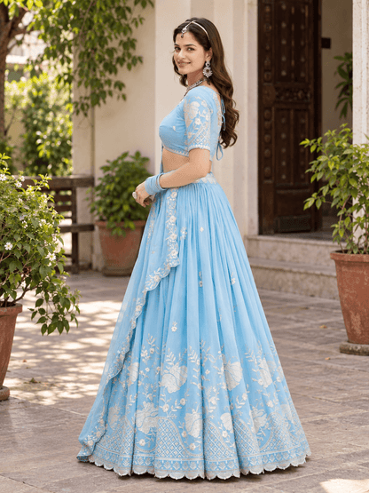 Side view of model wearing sky blue pleated lehenga with embroidered skirt border and matching dupatta